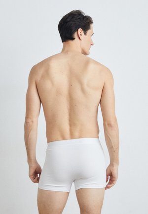 Hvide boxershorts med en glat tekstur og en blød talje. Synlig hud og muskuløs ryg, med minimale detaljer eller accenter.