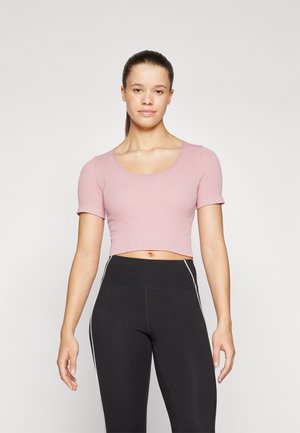 Lys rosa cropped topp med korte ermer, ribbet struktur og rund halslinning, sammen med høytlivs sorte leggings med hvite detaljer.