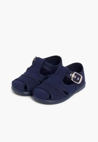 Navy blue canvas sandals featuring a buckled strap, open toe, and closed heel design. Smooth texture with reinforced stitching.