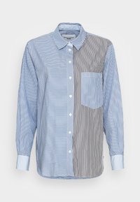 Randig skjorta med knappar i kontrasterande blå och svarta ränder, med en bröstficka och klassisk krage. Tillverkad av ett lätt tyg.