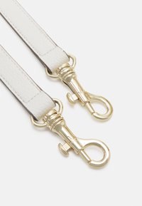 Bracelet en cuir blanc avec des fermoirs en métal doré, surface texturée et couture de contraste. Matériel d'ajustement inclus.