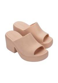 Beżowe mule na platformie z otwartym noskiem, wykonane z gładkiego, błyszczącego materiału; posiadają szeroką górną taśmę oraz masywny obcas z teksturowaną podeszwą dla lepszej przyczepności.