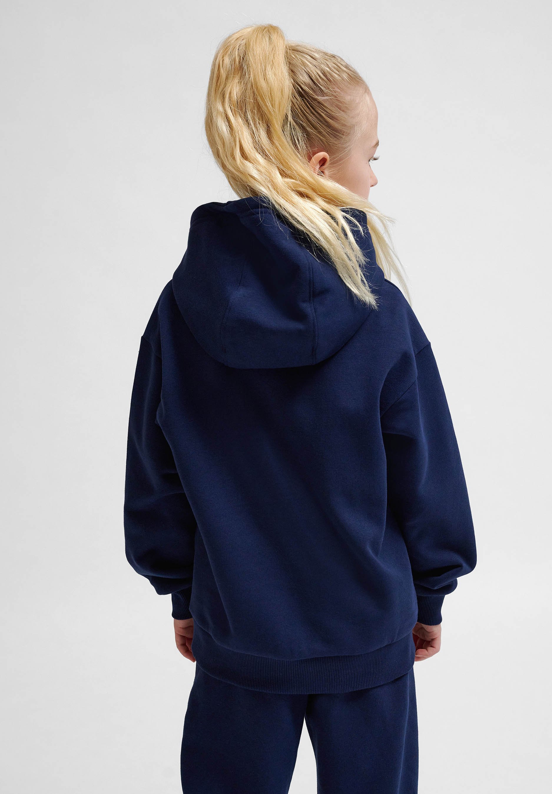 Mørkeblå hoodie lavet af blødt stof, med en stor hætte, ribbede manchetter og en afslappet pasform, set fra ryggen.