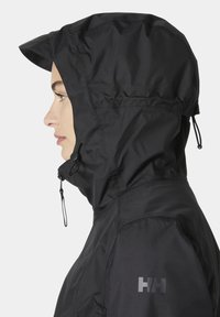 Μαύρο αδιάβροχο μπουφάν με κουκούλα, που διαθέτει ψηλό γιακά, ρυθμιζόμενα κορδόνια και ματ λογότυπο στον αριστερό ώμο.