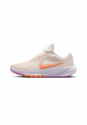 Zapatilla de correr Nike de color beige claro con swoosh naranja, parte superior de malla, entresuela blanca y suela de goma rosa y naranja.