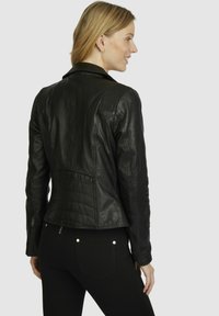 Black leather jacket featuring a fitted design, ribbed shoulder accents, and zippered sleeves, viewed from the back.