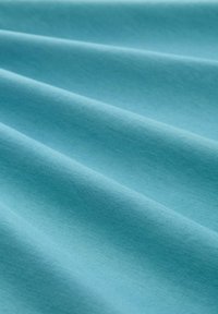 Helles blaues Gewebe mit glatter Textur, das dezente Falten und ein gleichmäßiges Oberflächendesign aufweist. Geeignet für verschiedene textile Anwendungen.