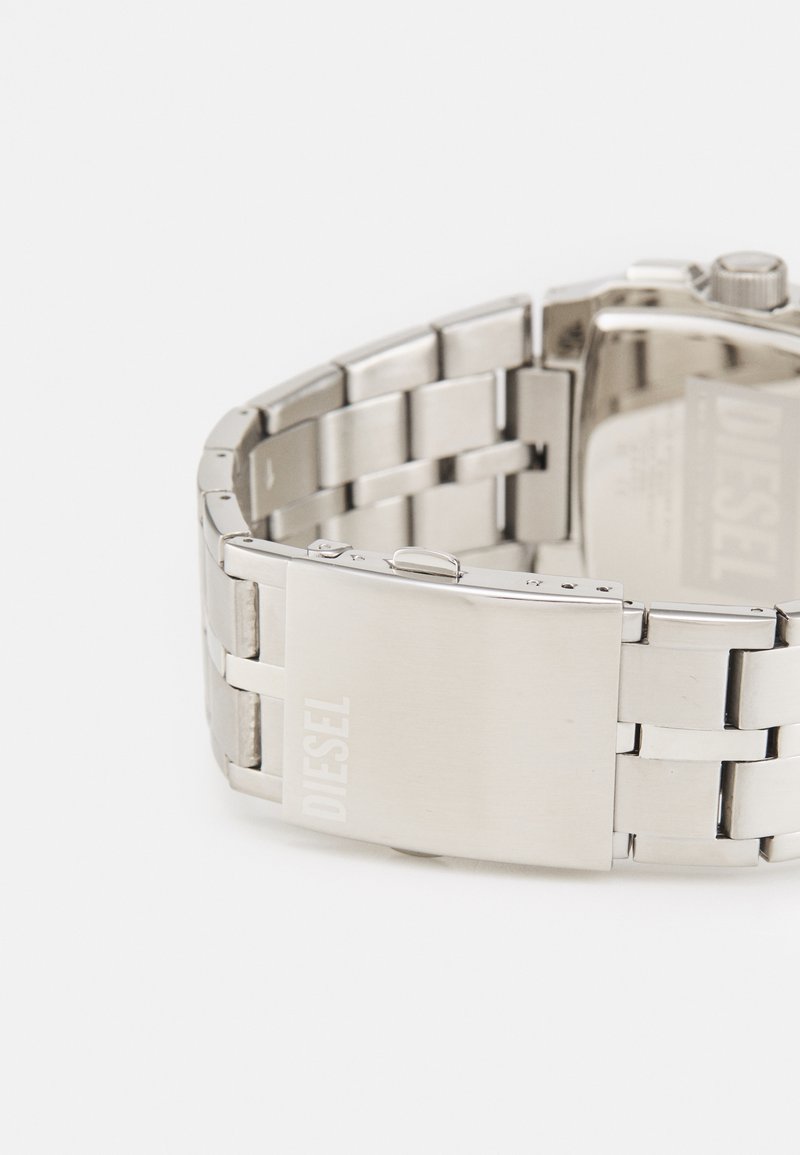 Silberner Edelstahlarmbanduhr mit einem verknüpften Armbanddesign, rechteckigem Zifferblatt und polierter Oberfläche. Verfügt über einen versteckten Verschluss und ein graviertes Logo.