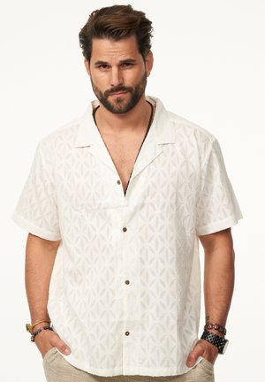 Kurze weiße Hemd mit geometrischem Muster, offenem Kragen, braunen Knöpfen und lässiger Passform, aus leichtem Stoff gefertigt.