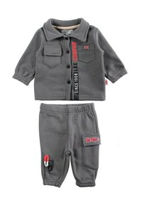 Tenue grise pour enfant comprenant un haut boutonné avec deux poches, et un pantalon avec une taille élastique et une poche latérale. Comprend des détails avec le logo de la marque.