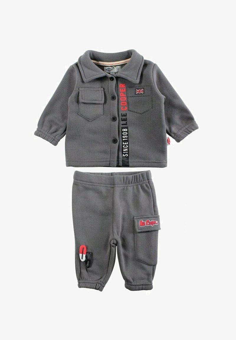 Tenue grise pour enfant comprenant un haut boutonné avec deux poches, et un pantalon avec une taille élastique et une poche latérale. Comprend des détails avec le logo de la marque.