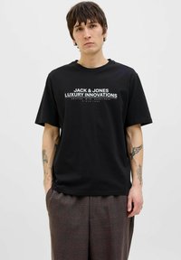 Svart bomullströja med korta ärmar, med vit textlogotyp "JACK & JONES LUXURY INNOVATIONS" över bröstet.