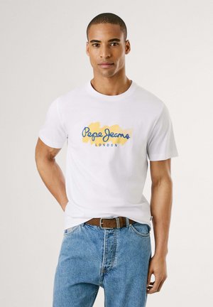 Weißes Baumwoll-T-Shirt mit einem blauen und gelben Logo-Design "Pepe Jeans London". Rundhalsausschnitt, kurze Ärmel, kombiniert mit blauen Jeans.