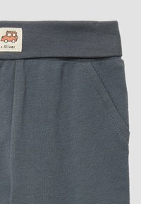 Grijze katoenen broek met een brede elastische tailleband en voorzakken. Voorzien van een klein label met een illustratie van een rode voertuig.