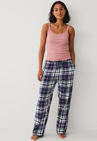 Roze mouwloze top met kantafwerking, gecombineerd met marineblauwe en witte geruite pyjamabroek met roze accenten en een elastische tailleband met trekkoord.