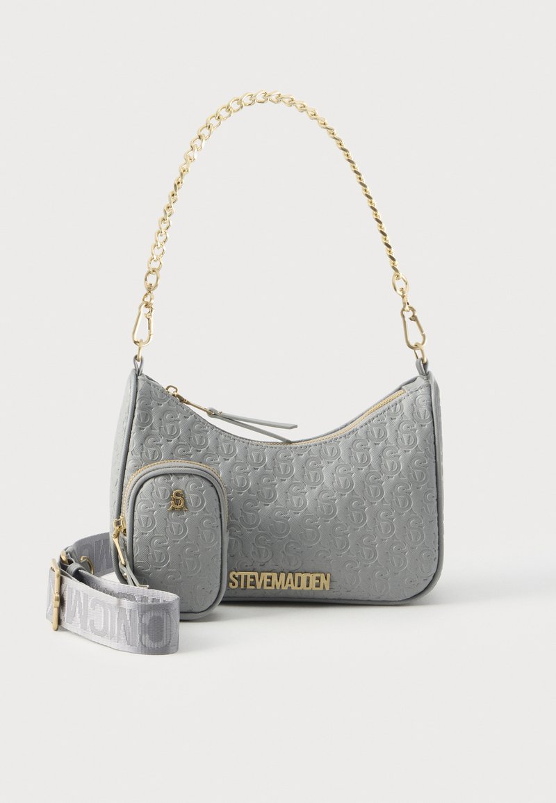 Sac à main gris Steve Madden avec anse chaîne dorée, petite pochette avant et bandoulière réglable en tissu avec impression du logo.