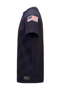 T-shirt blu navy a maniche corte con un motivo a strisce diagonali testurizzate. Presenta un ricamo della bandiera americana sulla spalla sinistra e un'etichetta con il logo del marchio.