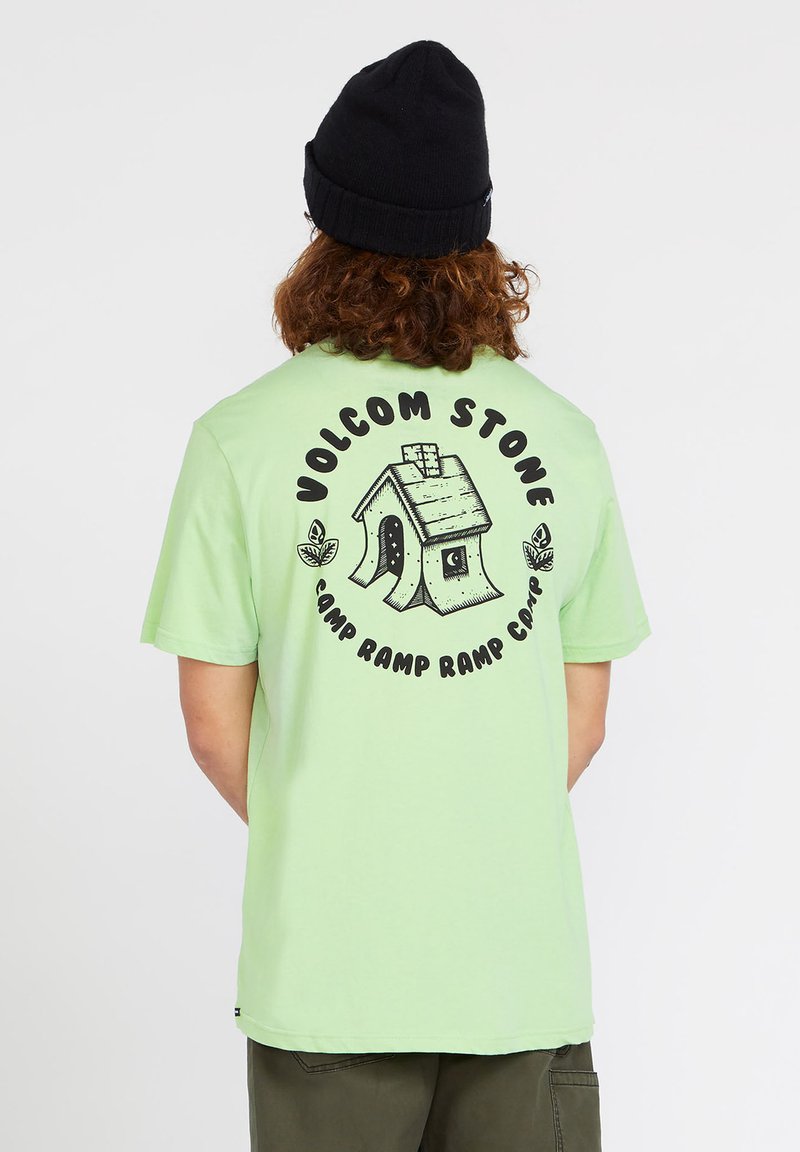 Camiseta de algodón verde claro con un diseño gráfico de una pequeña casa y el texto "VOLCOM STONE Camp Ramp Ramp Camp" en negro.