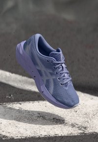 Αθλητικό παπούτσι σε ανοιχτό μωβ χρώμα με επάνω μέρος από διχτυωτό ύφασμα, στρογγυλή μύτη και υφασμένο πέλμα που διαθέτει λευκό λογότυπο στο πλάι.