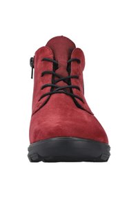 Bottines en cuir suédé rouge avec des lacets noirs et une fermeture éclair décorative sur le côté. La semelle en caoutchouc offre adhérence et stabilité.