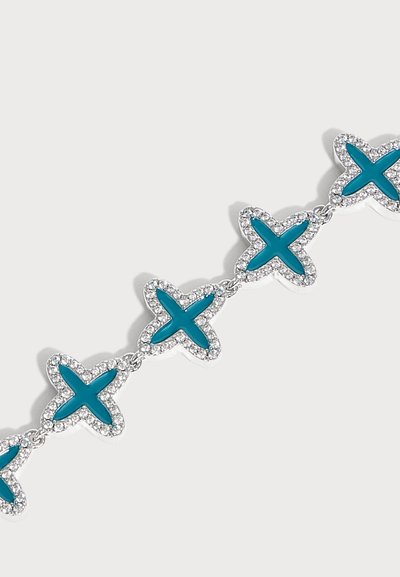Bracelet en argent avec breloques en forme d'étoile reliées, avec des centres turquoise et entourées de petites pierres précieuses transparentes sur fond blanc.