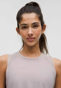 Haut sans manches rose pâle avec un col rond et des accents en mesh transparent sur les épaules, fabriqué dans un tissu lisse et extensible sans motifs.