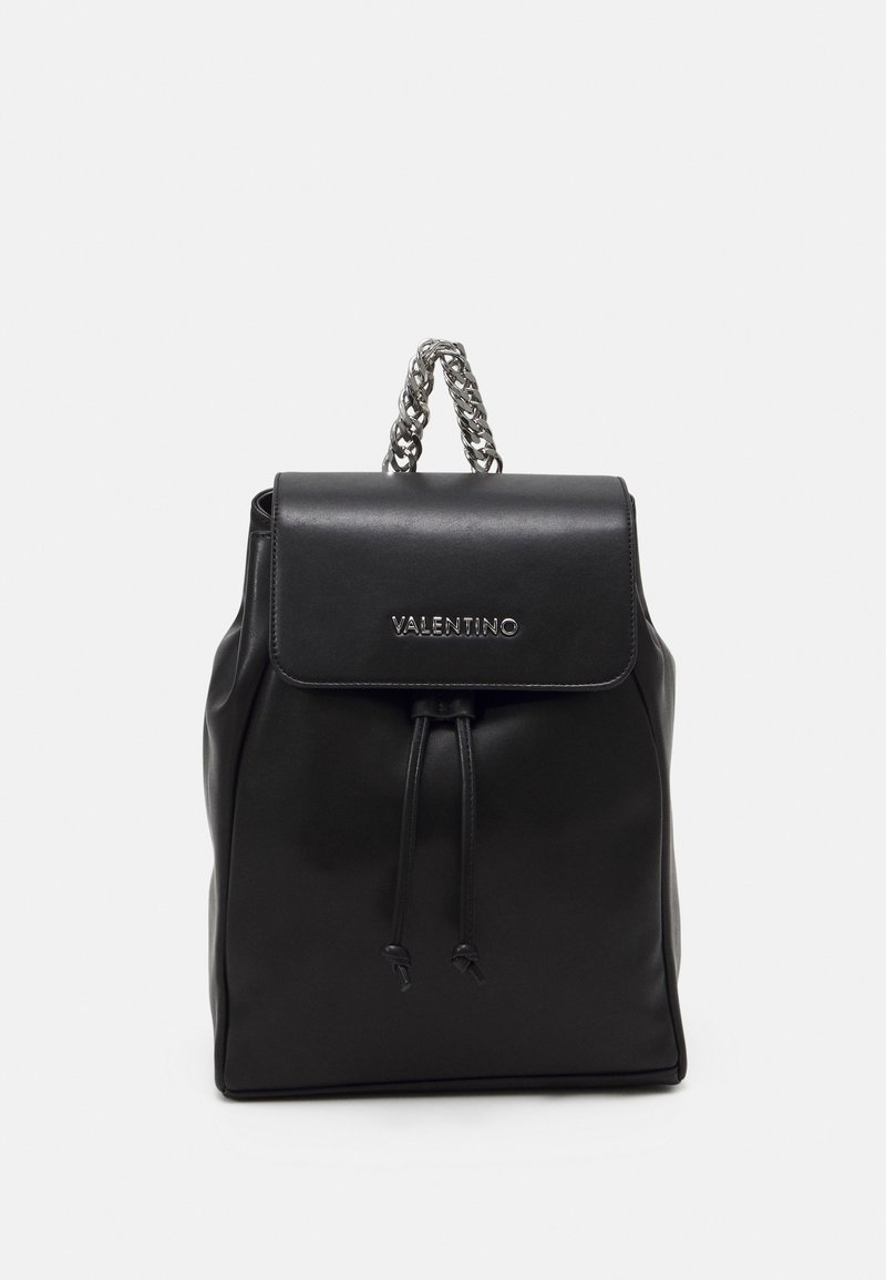 Black leather backpack with a flap closure, silver chain handle, drawstring detail, and embossed logo on the front. Smooth texture.