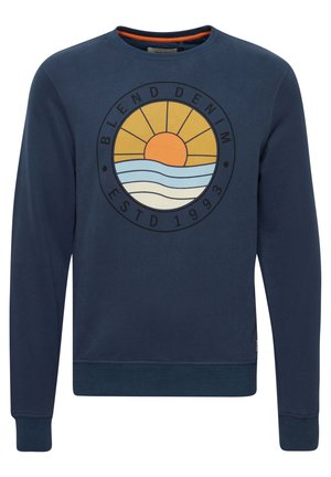 Tmavomodrý sveter vyrobený z bavlny, s okrúhlym výstrihom a rebrovanými manžetami. Predný grafický motív zobrazuje slnko a vlny s textom "BLEND DENIM."