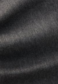 Tissu en feutre gris foncé avec une surface douce et texturée, présentant des variations de teinte subtiles et un aspect légèrement duveteux.