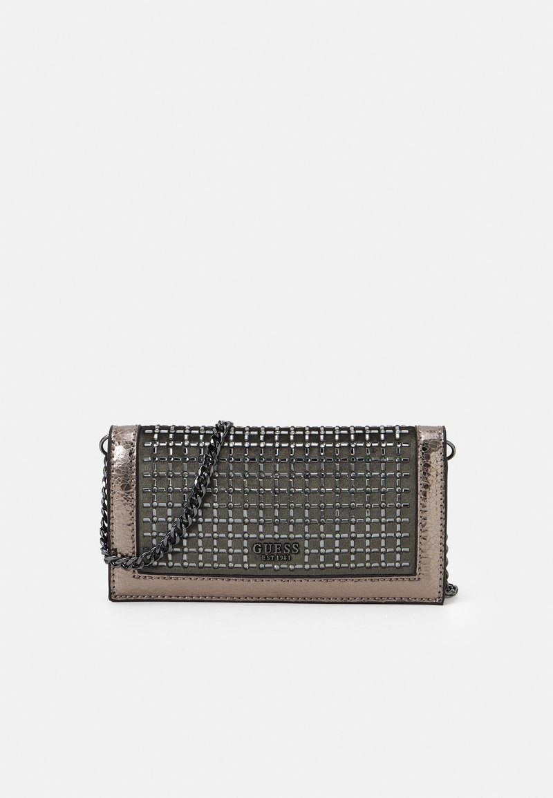 Schwarze und metallic-bronzene Guess-Clutch mit quadratischem Nietenmuster und abnehmbarem Kettenriemen auf einem weißen Hintergrund.