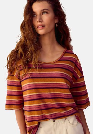 Striped short-sleeve top in orange, pink, and purple hues. Soft fabric with a relaxed fit and a round neckline, featuring a subtle hemline detail.