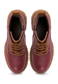 Botas de tobillo de cuero rojo con cordones marrones, parte superior texturizada, interior acolchado y suela de goma gruesa con un agarre con patrón.