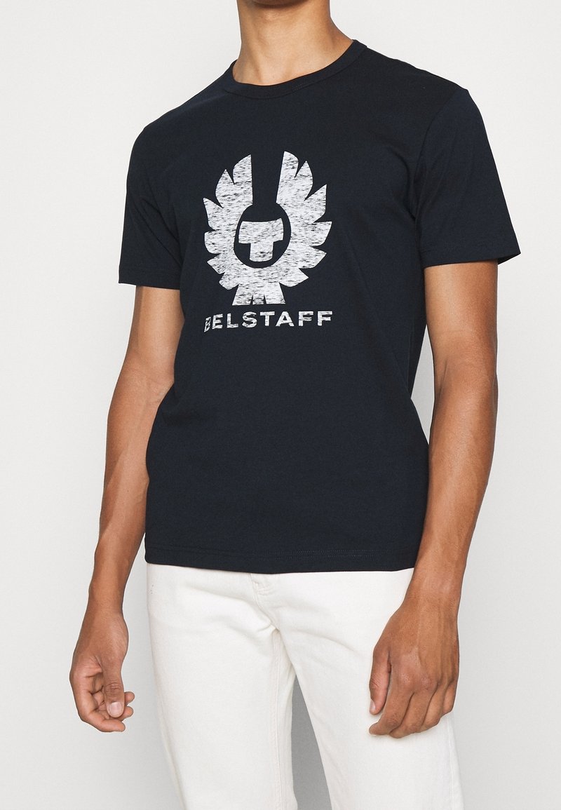 Schwarzes Baumwoll-T-Shirt mit einem großen weißen Grafiklogo mit Flügeln. Kurze Ärmel und Rundhalsausschnitt. Glatte Textur und taillierte Passform.