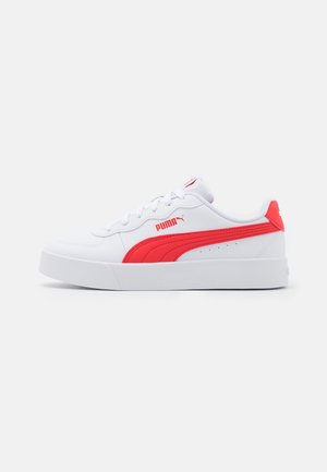 Biały sneaker Puma z czerwonym paskiem i logo z boku, niska konstrukcja, białe sznurowadła i gruba biała podeszwa.