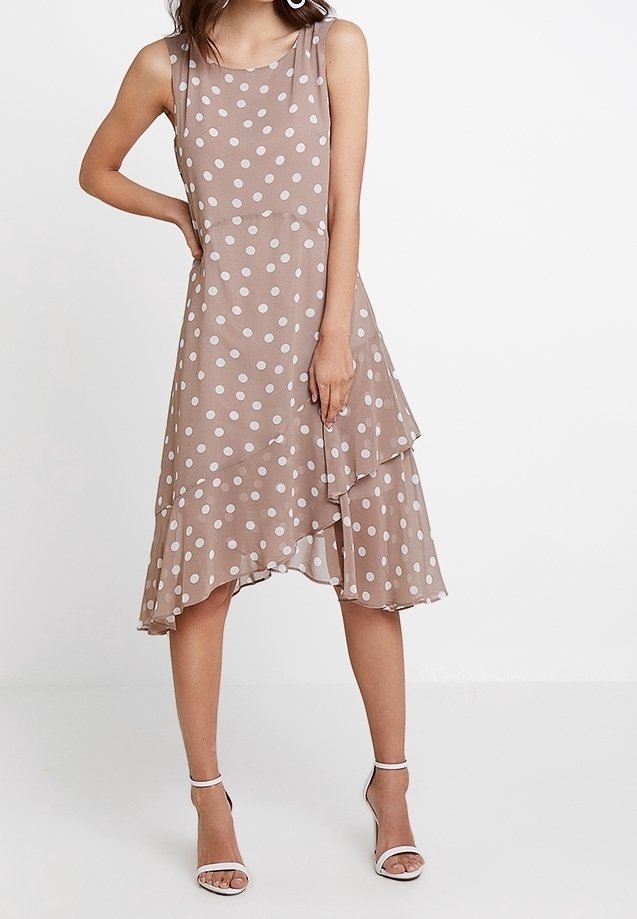 Braunes Kleid mit Polka-Punkten und geschichtetem Saum. Hergestellt aus leichtem Stoff, hat es ein ärmelloses Design und einen runden Ausschnitt.