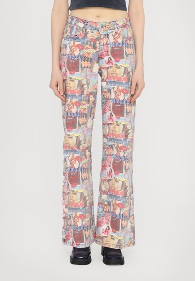 Jeans sbiaditi con una stampa collage colorata che presenta immagini retrò, accenti e testo. Hanno una forma a zampa d'elefante e una finitura in denim classica.
