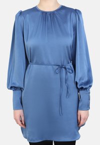 Blauwe satijnen jurk met lange opgeblazen mouwen, ronde halslijn en een strikceintuur in de taille. Gladde textuur en subtiele glans, met knoopaccenten.