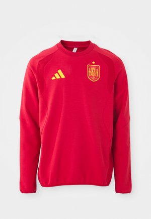 Sweatshirt vermelho com mangas longas, decote redondo, painéis texturizados nos ombros, um logotipo amarelo da Adidas e um emblema amarelo da seleção nacional de Espanha.