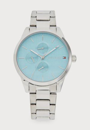 Orologio in acciaio inox argento con quadrante testurizzato azzurro chiaro, tre sotto-quadranti e indicatori delle ore argentati. Include un bracciale in metallo lucido.
