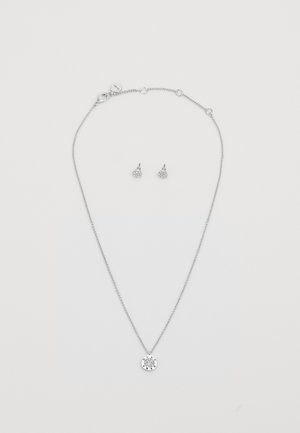 Collana d'argento con un ciondolo circolare caratterizzato da un design testurizzato, abbinata a orecchini a bottone coordinati, il tutto con una finitura lucida.