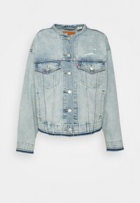 Světle modrá džínová bunda s cropped designem, dvěma náprsními kapsami, stříbrnými knoflíky a roztrhaným lemem. Obsahuje klasický límec a dlouhé rukávy.