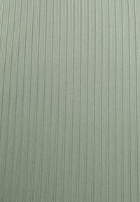 Tecido verde claro com um padrão texturizado de riscas verticais, criando uma aparência subtil e nervurada. Textura suave com brilho mínimo.