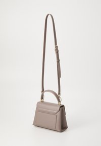Sac à main structuré en cuir gris doux avec une poignée supérieure et une bandoulière réglable. Il comporte une poche avant et des accents en matériel doré.