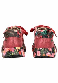 Chaussures en daim rose avec un motif floral sur le talon et la semelle. Comprend des lacets à pois rouges et un doublure intérieure douce.