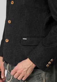 Gray wool jacket with wooden buttons, single chest pocket, textured fabric, and tailored fit, featuring three-button closure on the cuff.