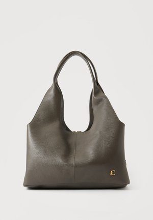 Sac à main en cuir gris foncé avec doubles anses et un petit emblème doré en forme de lettre C en bas à droite.