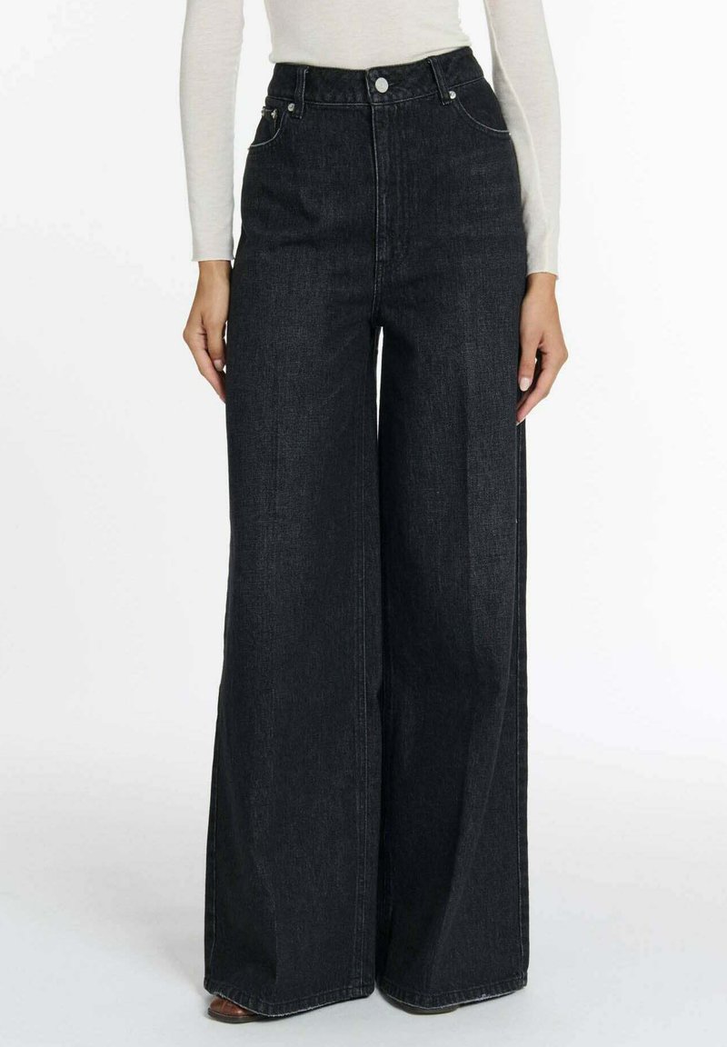 Hoge taille, wijde pijpen zwarte jeans van een gestructureerde denimstof, met een knoop- en ritssluiting en twee frontzakken.