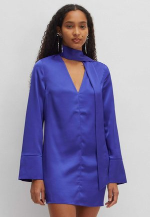 Lila Satin-Mini-Kleid mit V-Ausschnitt und langen Glockenärmeln. Es verfügt über eine Bindeschließe am Hals und eine glatte, glänzende Textur.