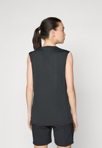 Dunkelgrå ermeløs topp med rund hals og rett kant, laget av mykt stoff. Brukt med svarte shorts, som viser et enkelt design.