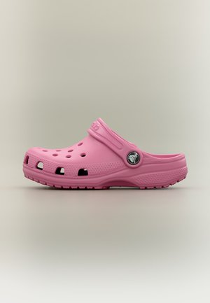 Ροζ κλειστές μοκασίνες slip-on με οπές αερισμού, ρυθμιζόμενο λουράκι στη φτέρνα και υφή στη σόλα σε απλό ουδέτερο φόντο.